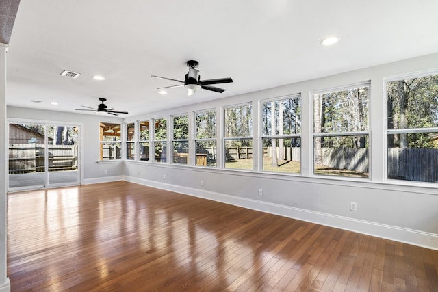 unfurnished sunroom with a ceiling fan and visible vents