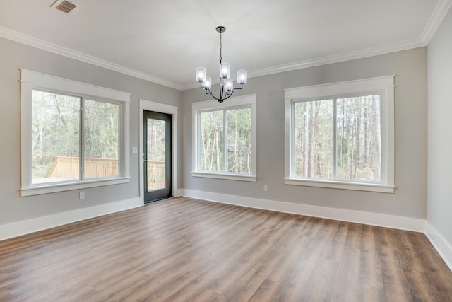 unfurnished room with hardwood / wood-style floors, an inviting chandelier, and ornamental molding