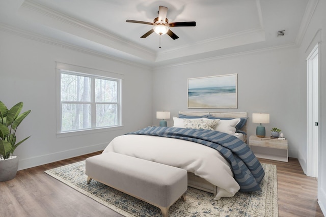 bedroom featuring ceiling fan, crown molding, and a raised ceiling