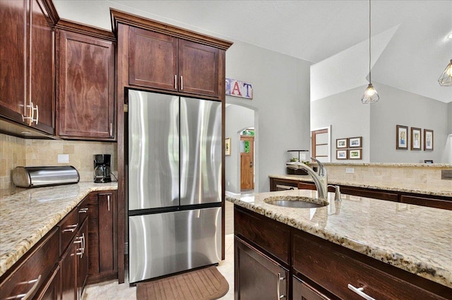 459 Oakwood Trl, Crawfordville, FL 32327 - kitchen featuring stainless steel refrigerator, tasteful backsplash, light stone counters, arched walkways, and vaulted ceiling