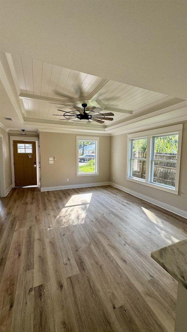 unfurnished living room with crown molding, a tray ceiling, a ceiling fan, wooden ceiling, and wood finished floors