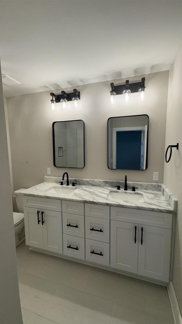 bathroom with double vanity and toilet