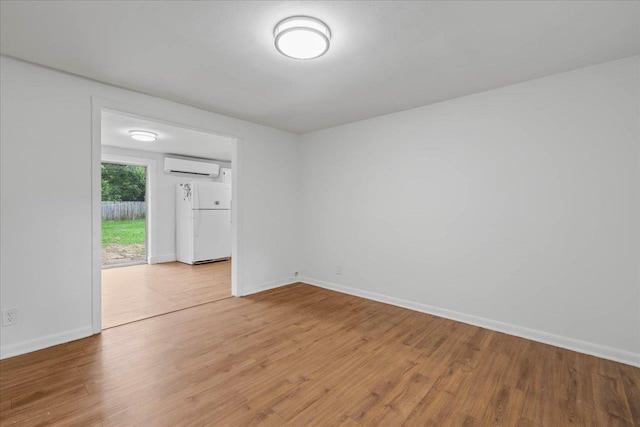 2014 Coffee Ln, Tallahassee, FL 32303 - spare room featuring an AC wall unit, light wood-type flooring, and baseboards