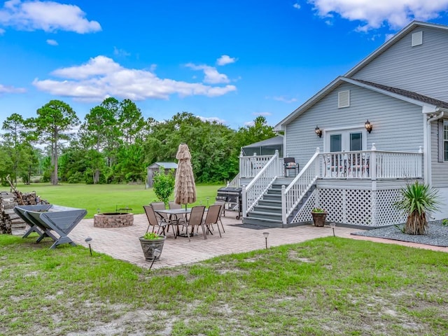 exterior space featuring a patio, a deck, french doors, and an outdoor fire pit