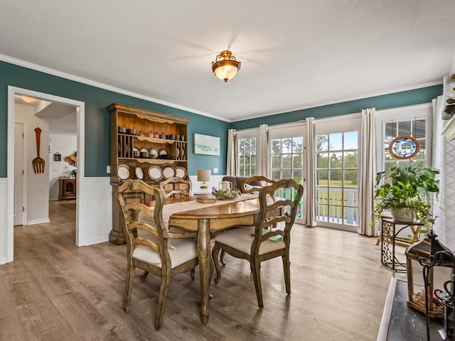 dining space with hardwood / wood-style floors and crown molding