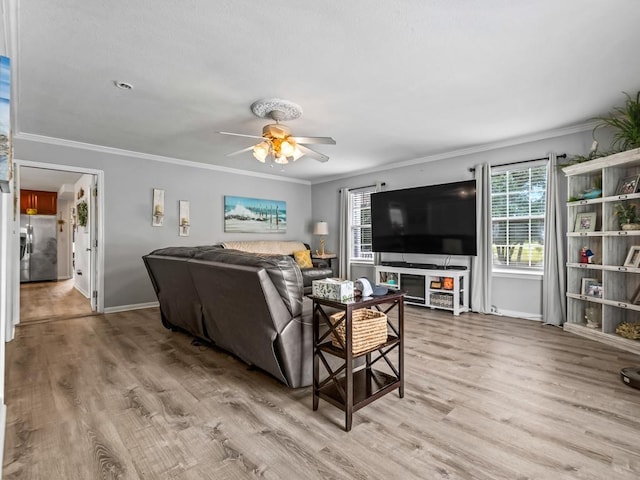 living room featuring crown molding, plenty of natural light, and light wood-type flooring