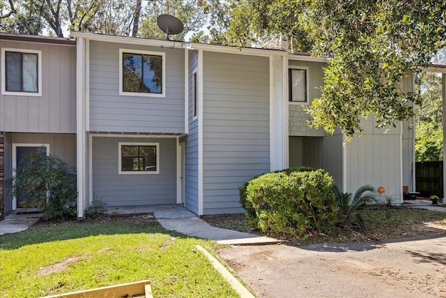 townhome / multi-family property featuring a front lawn