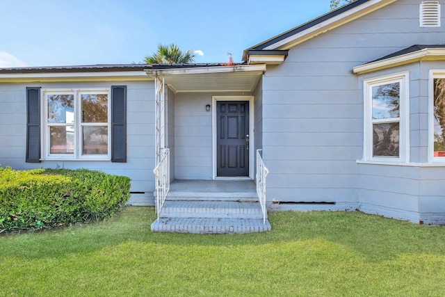 view of exterior entry featuring a yard