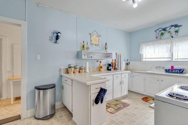 kitchen featuring white electric stove, white cabinets, light countertops, light floors, and open shelves