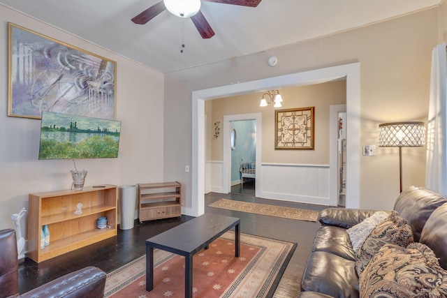 living room featuring dark wood finished floors and ceiling fan with notable chandelier