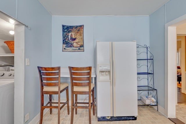 dining area featuring washer / dryer and baseboards