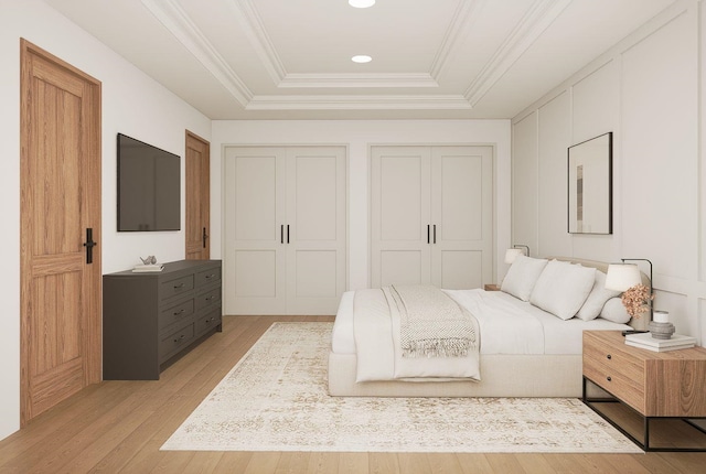606 Hampton Ave, Tallahassee, FL 32310 - bedroom featuring ornamental molding, a tray ceiling, light wood-style floors, two closets, and recessed lighting