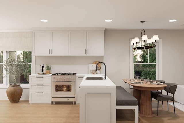 606 Hampton Ave, Tallahassee, FL 32310 - kitchen featuring light countertops, stainless steel stove, white cabinetry, pendant lighting, and a sink