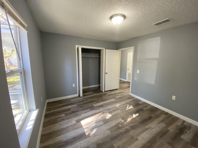 4350 Fortner Cir, Perry, FL 32347 - unfurnished bedroom with dark wood finished floors, a textured ceiling, and a closet