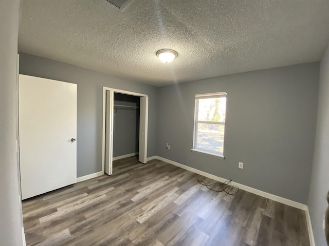 4350 Fortner Cir, Perry, FL 32347 - unfurnished bedroom with wood finished floors, a textured ceiling, and a closet