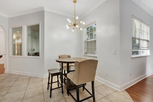 tiled dining area featuring an inviting chandelier and crown molding