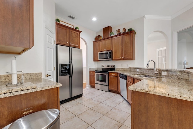 kitchen featuring light stone counters, sink, light tile patterned floors, crown molding, and appliances with stainless steel finishes