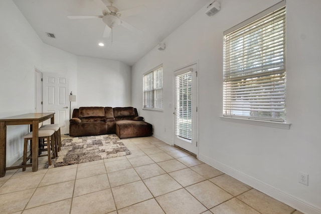 living room with lofted ceiling, light tile patterned flooring, and ceiling fan