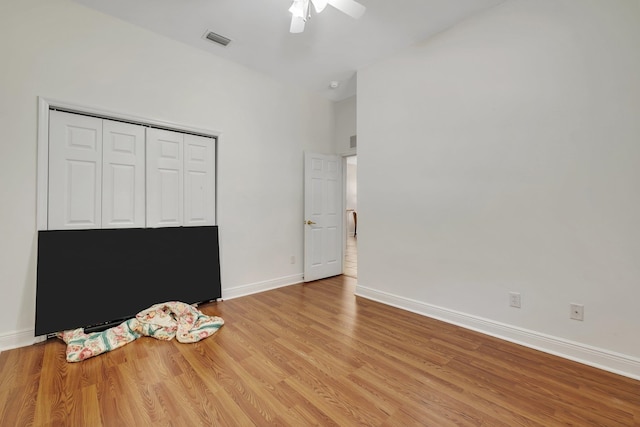 unfurnished bedroom with ceiling fan, a closet, and light wood-type flooring