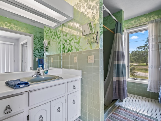 bathroom featuring tile patterned flooring, vanity, and curtained shower