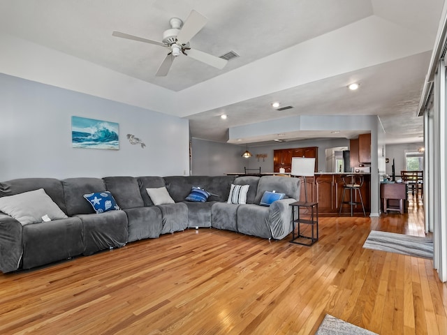 living room featuring ceiling fan and light hardwood / wood-style flooring