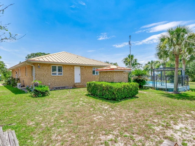 back of property featuring a lawn and a swimming pool