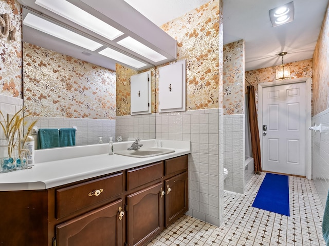 full bathroom with tile patterned floors, toilet, shower / bath combo with shower curtain, vanity, and tile walls