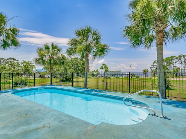 view of swimming pool with a yard