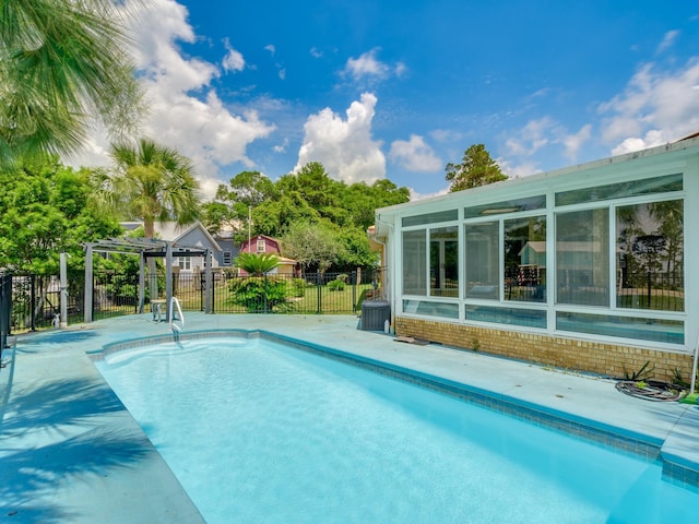 view of swimming pool featuring a pergola and a sunroom