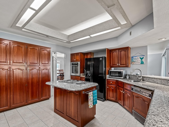 kitchen with a tray ceiling, sink, black appliances, light tile patterned floors, and a kitchen island