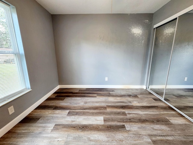 unfurnished bedroom featuring wood-type flooring and a closet