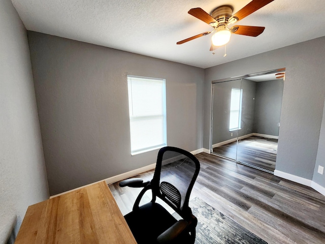 home office featuring a textured ceiling, dark hardwood / wood-style flooring, and ceiling fan