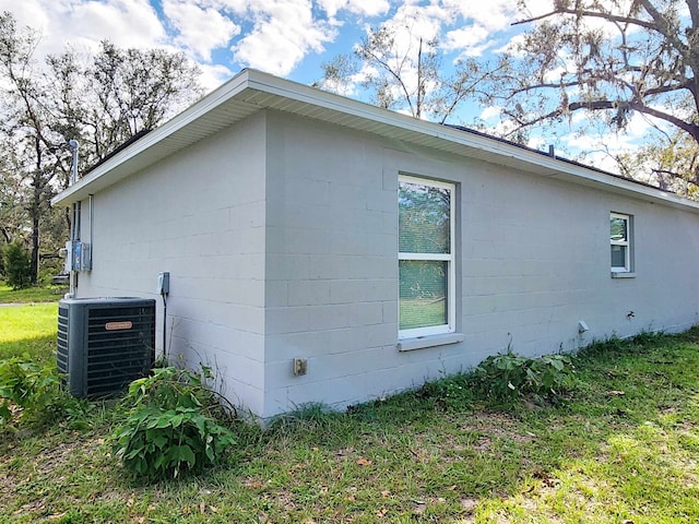 view of property exterior featuring central AC unit and a yard