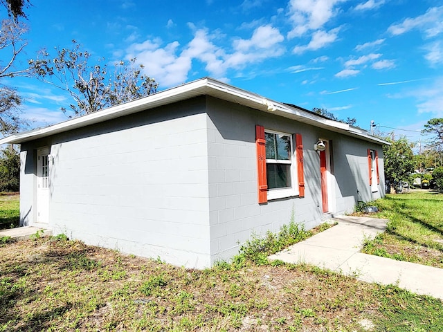 view of side of home with a yard