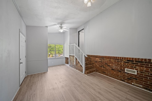 2401 Hideaway Ct, Tallahassee, FL 32303 - unfurnished living room featuring ceiling fan, wood finished floors, visible vents, and a textured ceiling