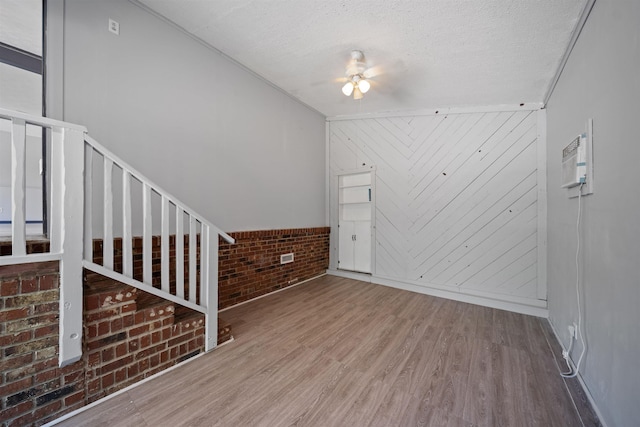 2401 Hideaway Ct, Tallahassee, FL 32303 - unfurnished living room featuring wood finished floors, a ceiling fan, brick wall, and wood walls