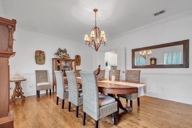 8555 Congressional Dr, Tallahassee, FL 32312 - dining space with a chandelier, crown molding, light wood finished floors, and baseboards