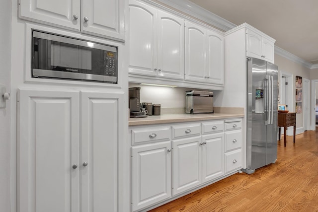 8555 Congressional Dr, Tallahassee, FL 32312 - kitchen featuring appliances with stainless steel finishes, ornamental molding, white cabinets, light countertops, and light wood-style flooring