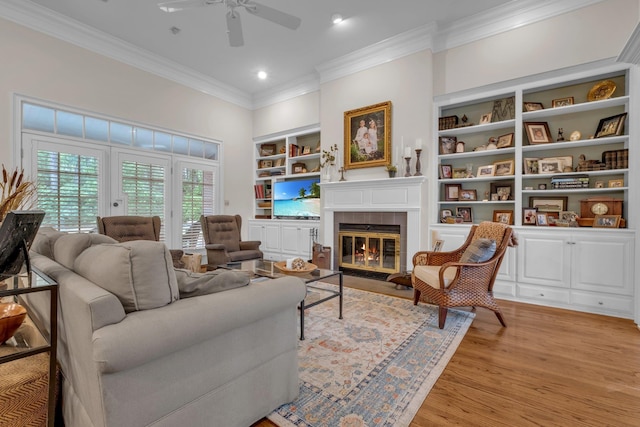 8555 Congressional Dr, Tallahassee, FL 32312 - living room with crown molding, a ceiling fan, built in features, light wood-style floors, and a tile fireplace