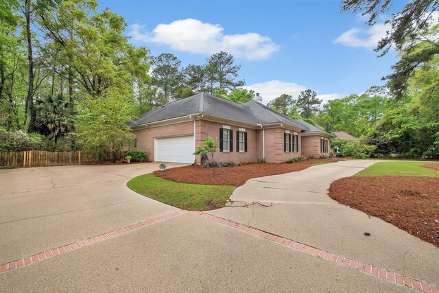 8555 Congressional Dr, Tallahassee, FL 32312 - view of front facade with concrete driveway, an attached garage, brick siding, a chimney, and roof with shingles