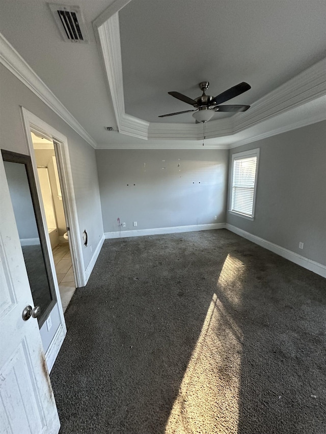 carpeted empty room featuring ceiling fan, crown molding, and a tray ceiling