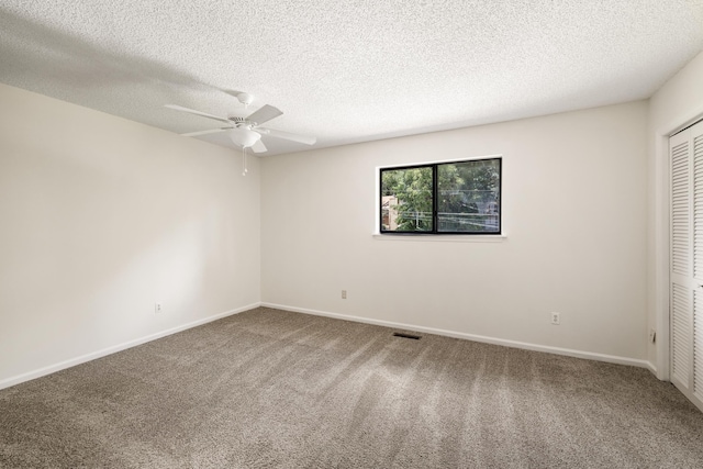 spare room featuring carpet flooring, ceiling fan, and a textured ceiling