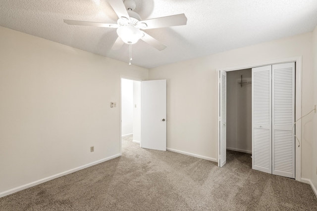 unfurnished bedroom with a textured ceiling, a closet, ceiling fan, and light colored carpet