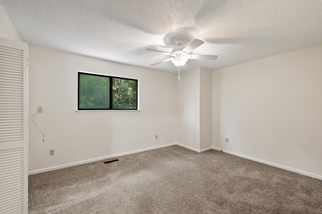 carpeted empty room featuring ceiling fan and a textured ceiling