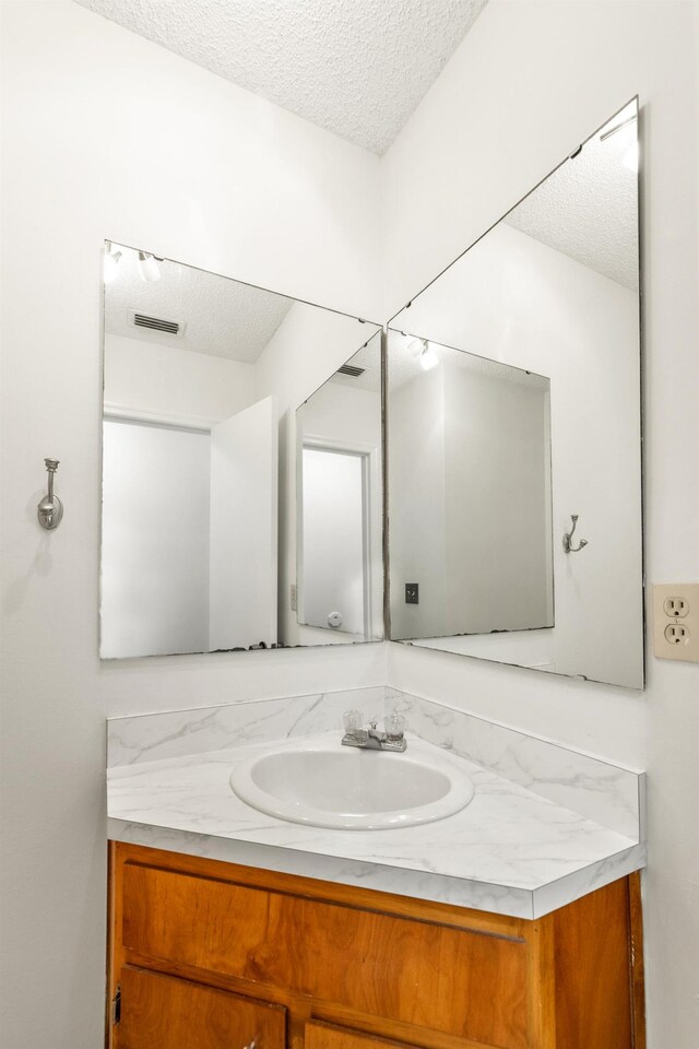 bathroom featuring a textured ceiling and vanity