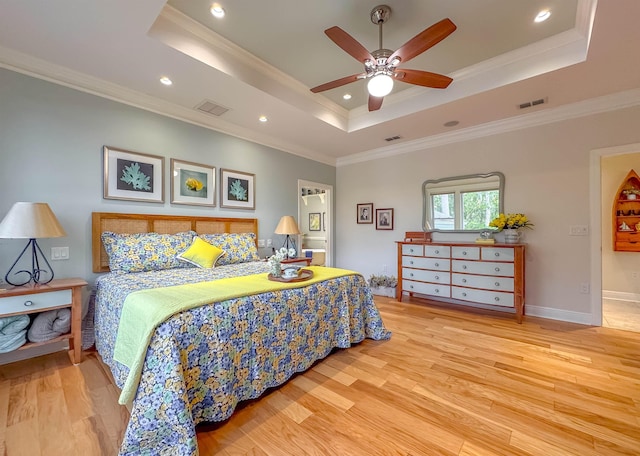 bedroom with visible vents, wood finished floors, ornamental molding, and a raised ceiling