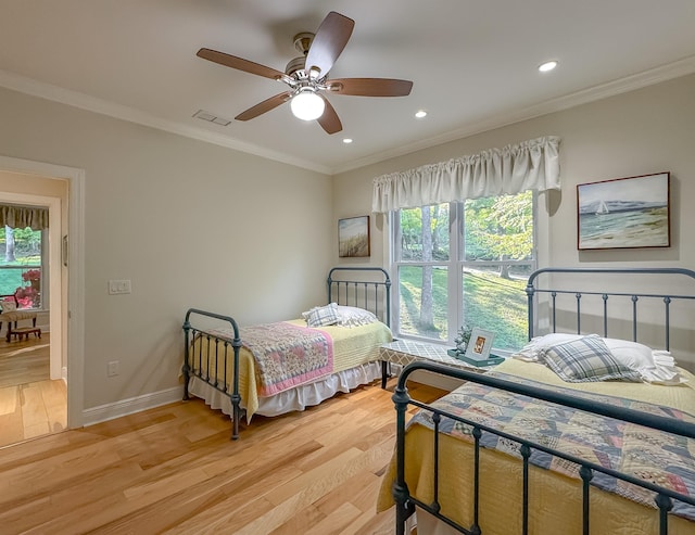 bedroom featuring light wood-style floors, visible vents, multiple windows, and crown molding