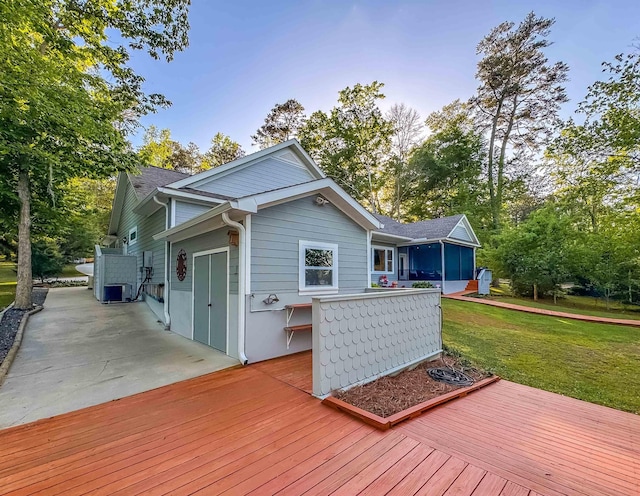 deck featuring a yard and a sunroom