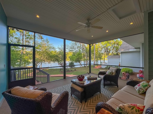 sunroom / solarium featuring an outdoor living space, ceiling fan, and a water view