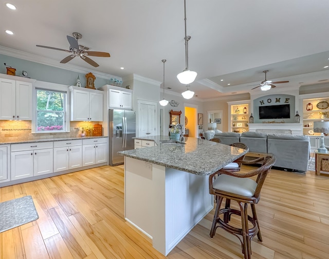 kitchen with stainless steel fridge with ice dispenser, light wood-style floors, a sink, and a ceiling fan